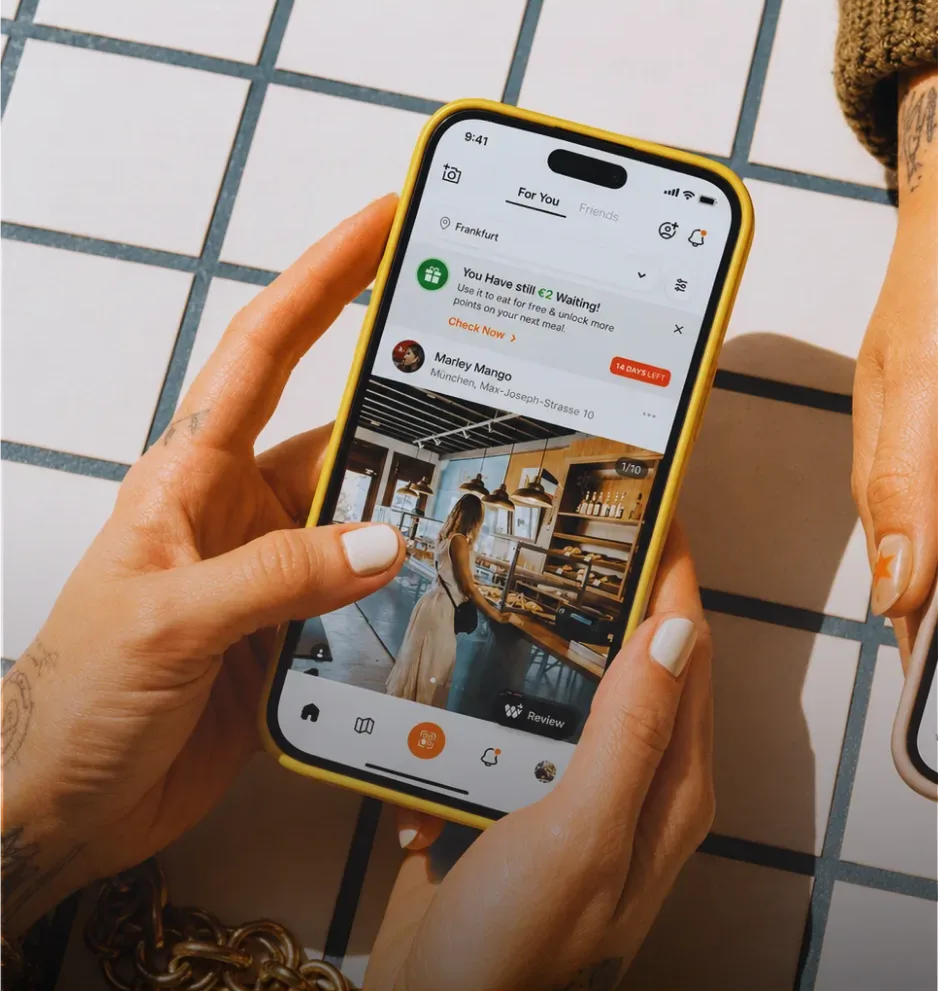 Eine Gästin durchstöbert den Wheretogo-Feed auf ihrem Handy